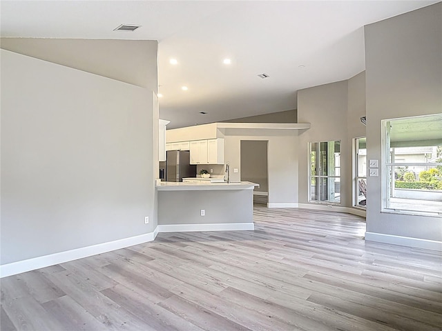 5809 Silas Creek Ln, Wesley Chapel, FL 33545 - unfurnished living room featuring high vaulted ceiling, light wood-style flooring, and recessed lighting