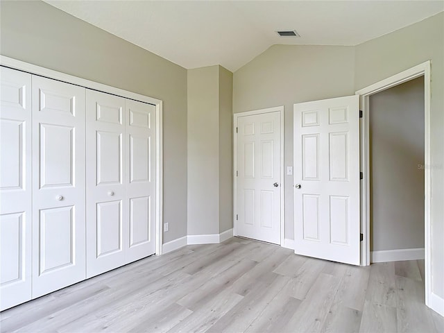 5809 Silas Creek Ln, Wesley Chapel, FL 33545 - unfurnished bedroom featuring light wood-style flooring, a closet, and lofted ceiling