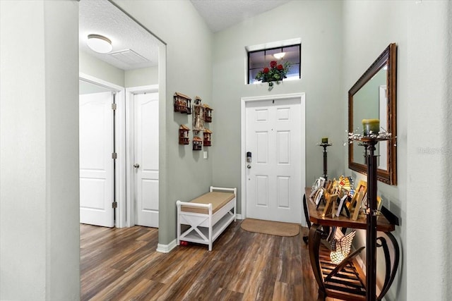 12026 Crestridge Loop, New Port Richey, FL 34655 - foyer featuring dark wood-style floors, a textured ceiling, and baseboards