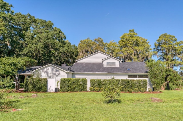 15612 Howell Park Ln, Tampa, FL 33625 - view of front of house with a front yard, a shingled roof, and a chimney