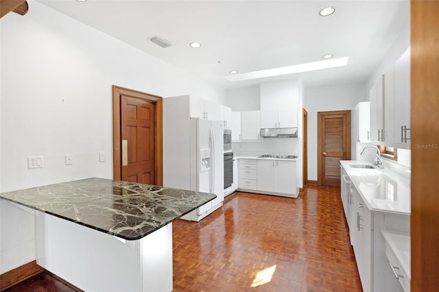 15612 Howell Park Ln, Tampa, FL 33625 - kitchen with a sink, under cabinet range hood, a peninsula, oven, and white cabinets