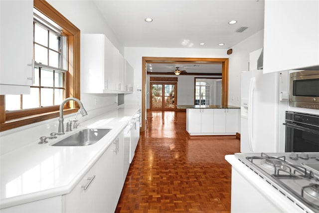 15612 Howell Park Ln, Tampa, FL 33625 - kitchen featuring black oven, a sink, white fridge with ice dispenser, stainless steel microwave, and white cabinetry