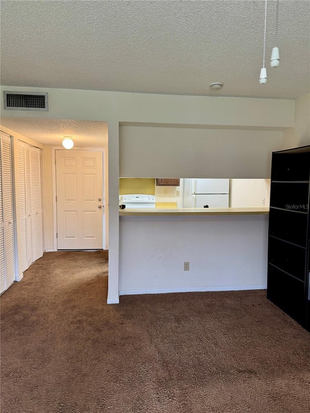 6324 Newtown Cir Unit 24B2, Tampa, FL 33615 - kitchen featuring carpet floors, white appliances, and a textured ceiling