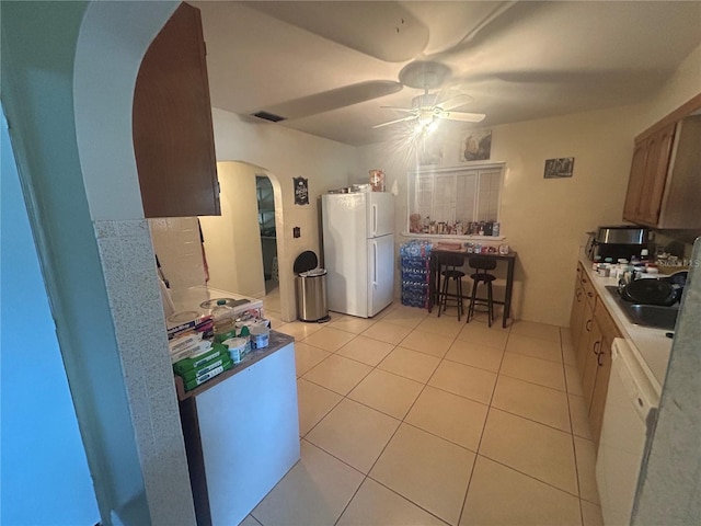 18133 US Highway 41, Spring Hill, FL 34610 - kitchen featuring white appliances, arched walkways, a ceiling fan, a sink, and light tile patterned flooring