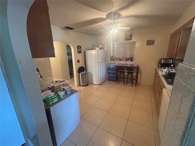 18133 US Highway 41, Spring Hill, FL 34610 - kitchen with freestanding refrigerator, arched walkways, a ceiling fan, and light tile patterned flooring