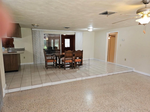 dining area with ceiling fan and speckled floor