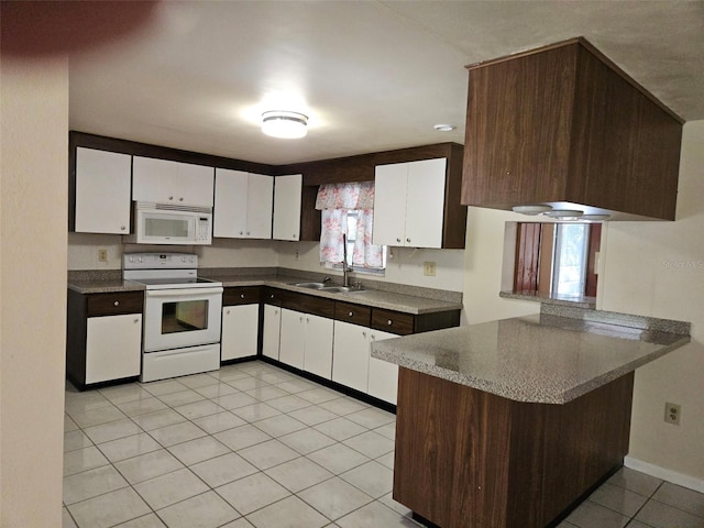 kitchen with white appliances, a peninsula, white cabinets, and light tile patterned flooring