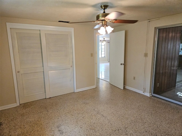 unfurnished bedroom featuring speckled floor, a closet, and a ceiling fan