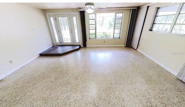 unfurnished room featuring ceiling fan and speckled floor