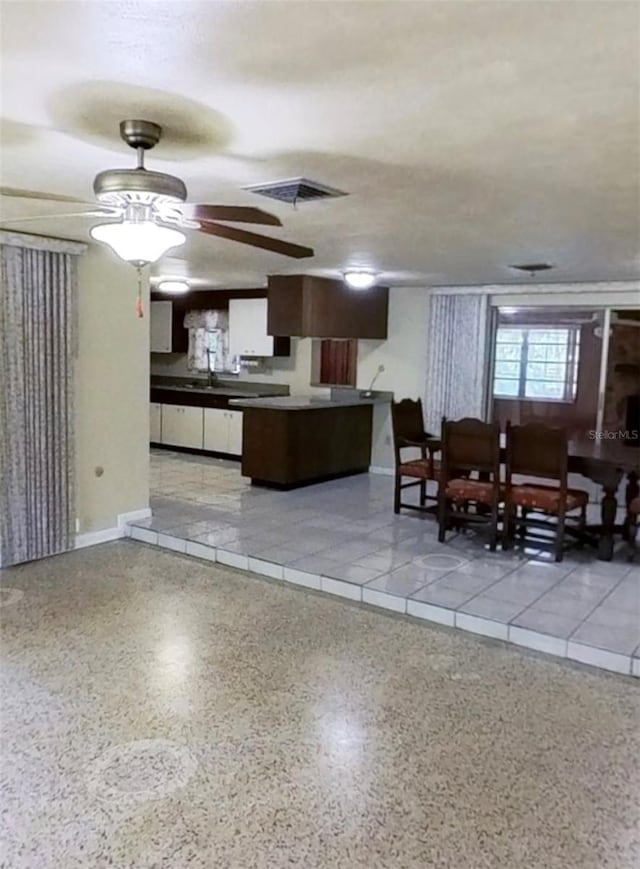 living area featuring speckle patterned floor and ceiling fan