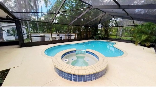 view of swimming pool with a pool with connected hot tub, glass enclosure, and a patio area