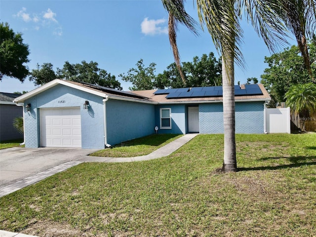 11521 Paperwood Pl, Riverview, FL 33579 - ranch-style home with a garage, solar panels, driveway, stucco siding, and brick siding