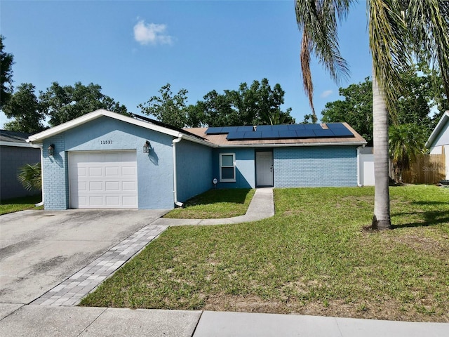 11521 Paperwood Pl, Riverview, FL 33579 - ranch-style house with an attached garage, roof mounted solar panels, asphalt driveway, brick siding, and stucco siding