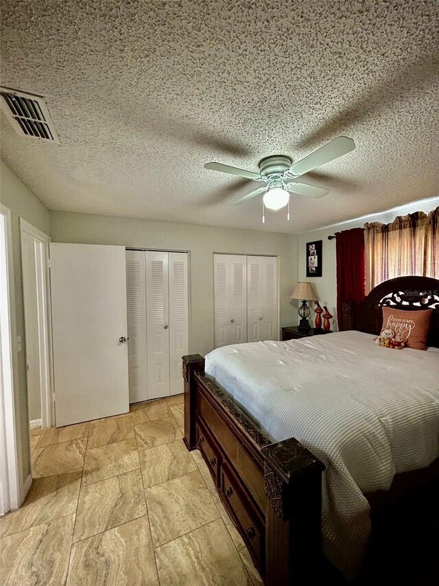11521 Paperwood Pl, Riverview, FL 33579 - bedroom with multiple closets, ceiling fan, and a textured ceiling