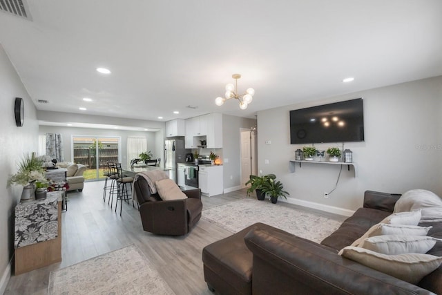 8339 75th Ave, Seminole, FL 33777 - living room featuring a chandelier, light wood-style floors, recessed lighting, and baseboards