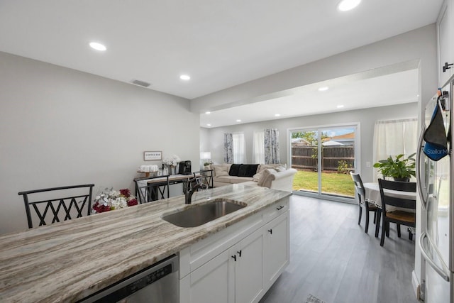 8339 75th Ave, Seminole, FL 33777 - kitchen with a sink, freestanding refrigerator, stainless steel dishwasher, light stone countertops, and recessed lighting