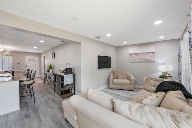 8339 75th Ave, Seminole, FL 33777 - living area with light wood-type flooring, recessed lighting, baseboards, and a chandelier