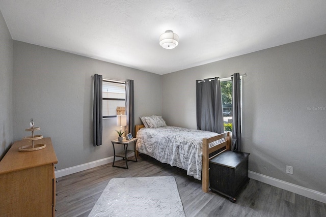 8339 75th Ave, Seminole, FL 33777 - bedroom featuring multiple windows, wood finished floors, and baseboards