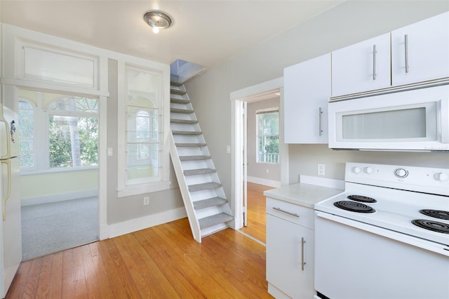 824 31st Ave N, Saint Petersburg, FL 33704 - kitchen featuring white appliances, light countertops, baseboards, and light wood-style flooring