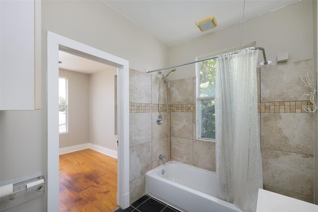 824 31st Ave N, Saint Petersburg, FL 33704 - bathroom with shower / tub combo, baseboards, and wood finished floors