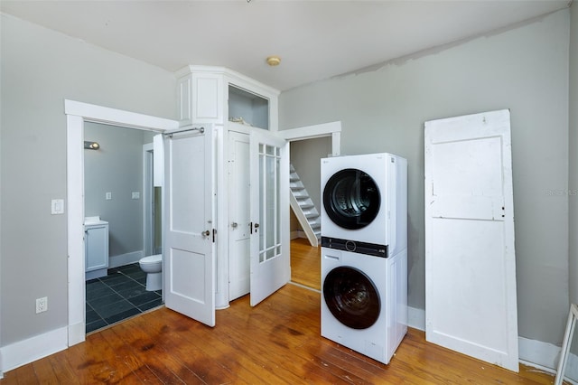 824 31st Ave N, Saint Petersburg, FL 33704 - laundry room featuring stacked washer and clothes dryer, hardwood / wood-style floors, and baseboards