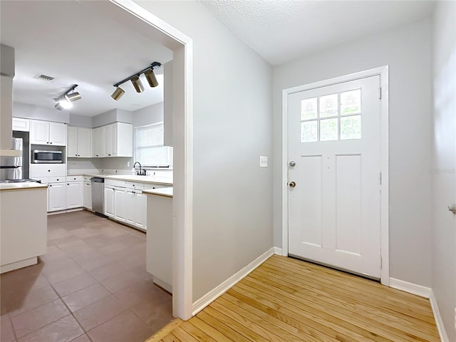 1737 Prince Philip St, Clearwater, FL 33755 - doorway to outside featuring plenty of natural light, a sink, baseboards, and rail lighting