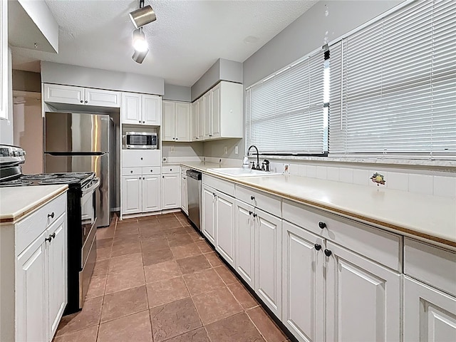 1737 Prince Philip St, Clearwater, FL 33755 - kitchen with stainless steel appliances, a sink, white cabinetry, light countertops, and a textured ceiling
