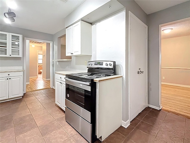 1737 Prince Philip St, Clearwater, FL 33755 - kitchen featuring stainless steel electric range oven, white cabinetry, light countertops, and baseboards