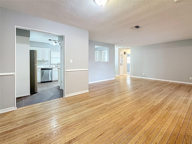 1737 Prince Philip St, Clearwater, FL 33755 - unfurnished room featuring light wood-style floors, baseboards, and a textured ceiling