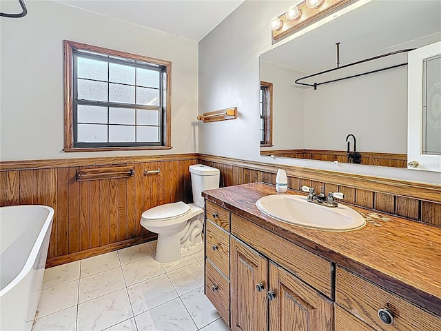 1737 Prince Philip St, Clearwater, FL 33755 - full bath with wainscoting, a freestanding tub, vanity, toilet, and wooden walls