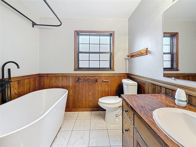 1737 Prince Philip St, Clearwater, FL 33755 - full bath with a wainscoted wall, a freestanding bath, marble look tile flooring, wood walls, and vanity