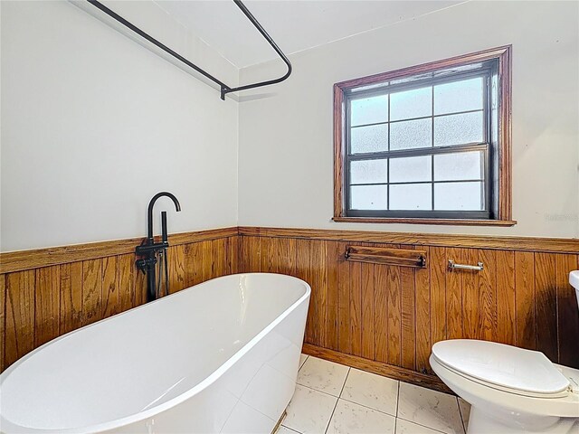 1737 Prince Philip St, Clearwater, FL 33755 - bathroom featuring a freestanding bath, wainscoting, healthy amount of natural light, toilet, and wood walls