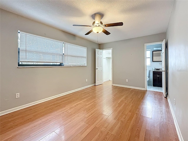 1737 Prince Philip St, Clearwater, FL 33755 - empty room with a ceiling fan, light wood-style flooring, a textured ceiling, and baseboards