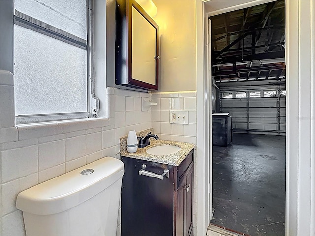 1737 Prince Philip St, Clearwater, FL 33755 - half bathroom with vanity, concrete floors, tile walls, and toilet
