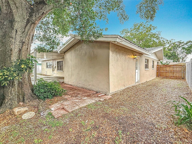 1737 Prince Philip St, Clearwater, FL 33755 - view of property exterior featuring stucco siding, a fenced backyard, and a patio area