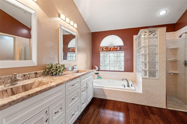 28390 Openfield Loop, Wesley Chapel, FL 33543 - bathroom with vaulted ceiling, double vanity, a bath, walk in shower, and wood finished floors