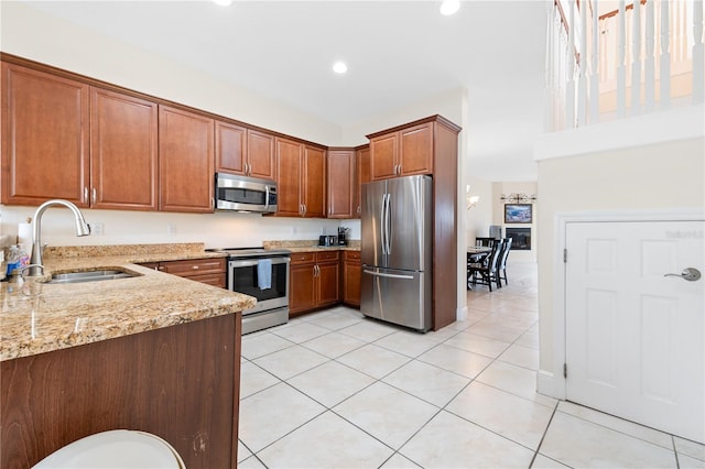 17817 Gulf Blvd Unit A, Saint Petersburg, FL 33708 - kitchen featuring appliances with stainless steel finishes, a sink, light stone counters, light tile patterned floors, and recessed lighting