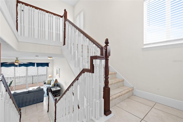 17817 Gulf Blvd Unit A, Saint Petersburg, FL 33708 - stairway featuring tile patterned floors, healthy amount of natural light, ceiling fan, and a towering ceiling