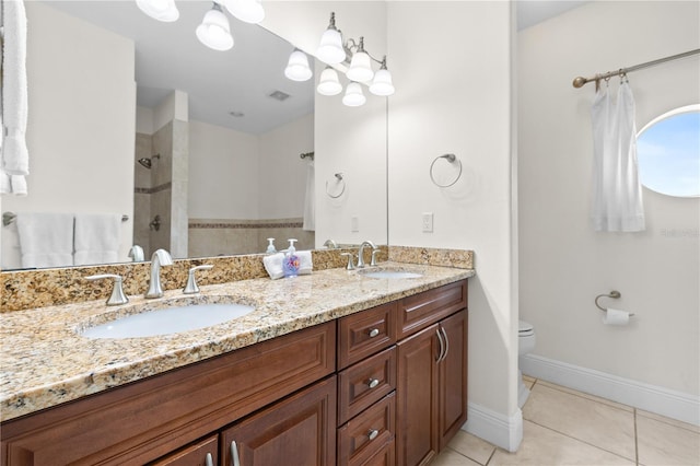 17817 Gulf Blvd Unit A, Saint Petersburg, FL 33708 - bathroom featuring tiled shower, double vanity, tile patterned flooring, toilet, and baseboards