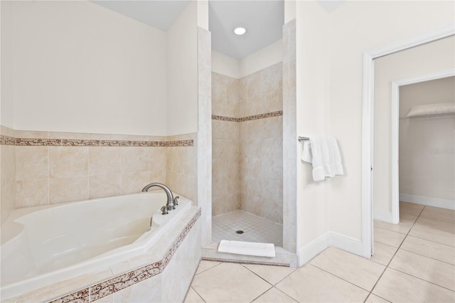 17817 Gulf Blvd Unit A, Saint Petersburg, FL 33708 - bathroom featuring tile patterned floors, a garden tub, a stall shower, baseboards, and a spacious closet