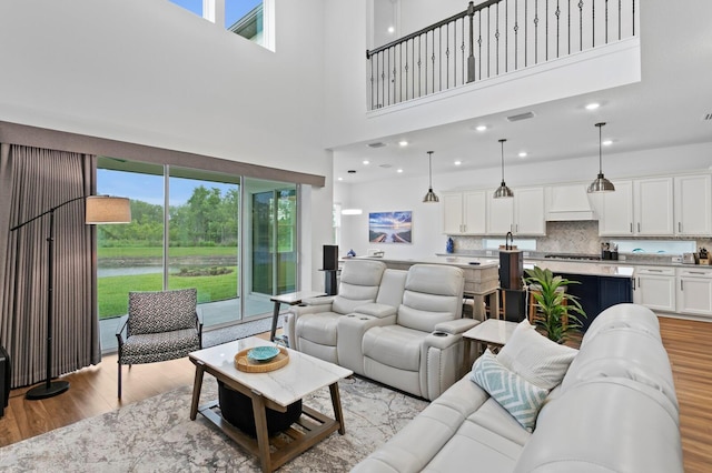 3559 Maple Bay Ln, Land O Lakes, FL 34638 - living room with light wood-style flooring, a towering ceiling, and a water view