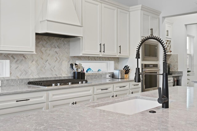 3559 Maple Bay Ln, Land O Lakes, FL 34638 - kitchen featuring custom range hood, stainless steel appliances, white cabinetry, and tasteful backsplash