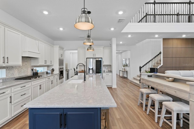 3559 Maple Bay Ln, Land O Lakes, FL 34638 - kitchen with appliances with stainless steel finishes, white cabinets, decorative backsplash, light wood-style flooring, and recessed lighting
