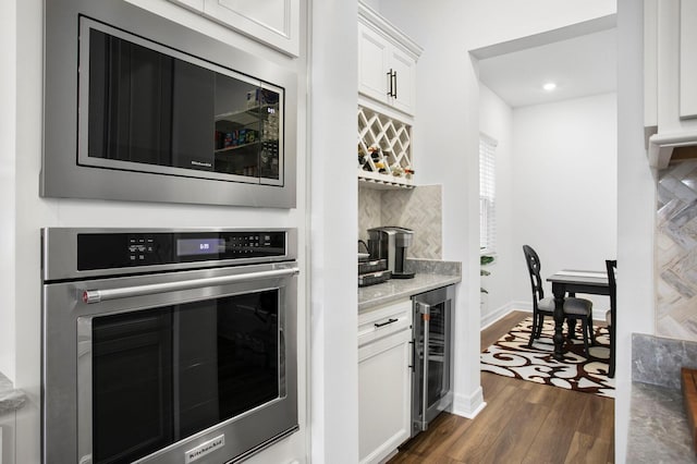 3559 Maple Bay Ln, Land O Lakes, FL 34638 - kitchen with stainless steel appliances, beverage cooler, dark wood-style floors, white cabinets, and backsplash