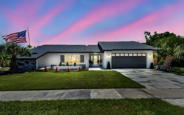 325 Gladstone Blvd, Englewood, FL 34223 - view of front of house with driveway, a garage, stucco siding, and a front lawn