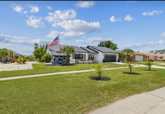 325 Gladstone Blvd, Englewood, FL 34223 - view of front of house featuring a garage, driveway, a front yard, a standing seam roof, and a metal roof