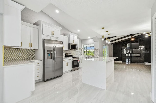 325 Gladstone Blvd, Englewood, FL 34223 - kitchen featuring appliances with stainless steel finishes, vaulted ceiling, light countertops, a kitchen island, and white cabinetry