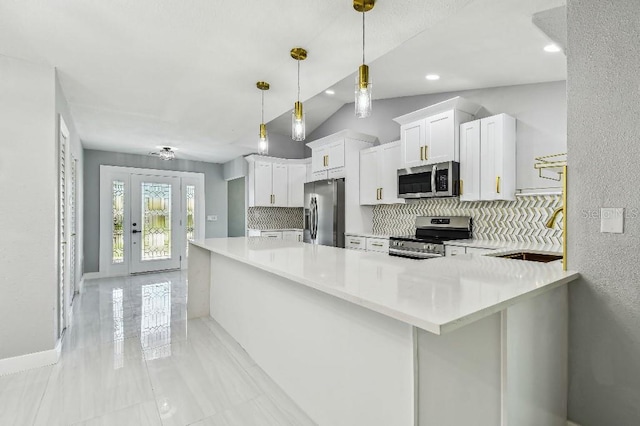 325 Gladstone Blvd, Englewood, FL 34223 - kitchen featuring appliances with stainless steel finishes, tasteful backsplash, light countertops, white cabinetry, and lofted ceiling