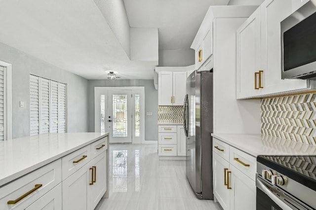 325 Gladstone Blvd, Englewood, FL 34223 - kitchen with appliances with stainless steel finishes, decorative backsplash, light countertops, and white cabinets
