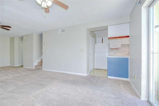 1799 N Highland Ave Unit 185, Clearwater, FL 33755 - unfurnished living room featuring a ceiling fan, light carpet, baseboards, and a textured ceiling